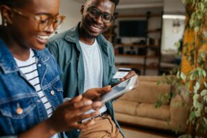 Black couple enjoying at home and using technology
